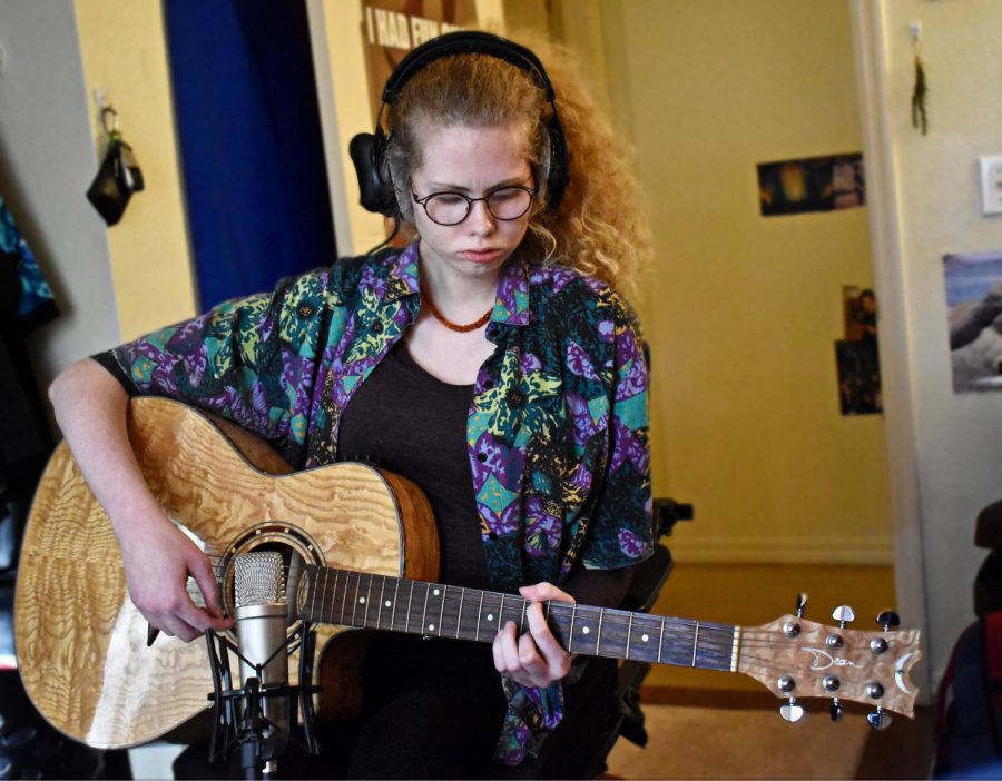 Gracie Caggiano '21 playing a guitar part for one of August Moon's tracks.