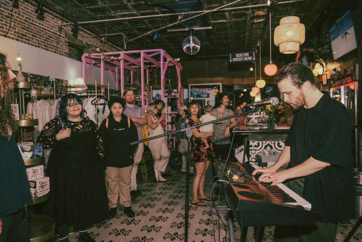 DeLand locals (left) socialize and watch a keyboardist and vocalist (right) perform original music at Sidecar Market and Books and Booking’s bimonthly open mic night.
